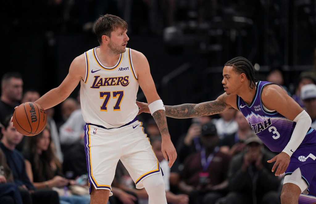 Los Angeles Lakers forward/guard Luka Dončić (77) dribbles as he is defended by Utah Jazz guard Keyonte George (3) during the second half of an NBA basketball game Sunday, Oct. 25, 2026, in Salt Lake City. (AP Photo/Bethany Baker)