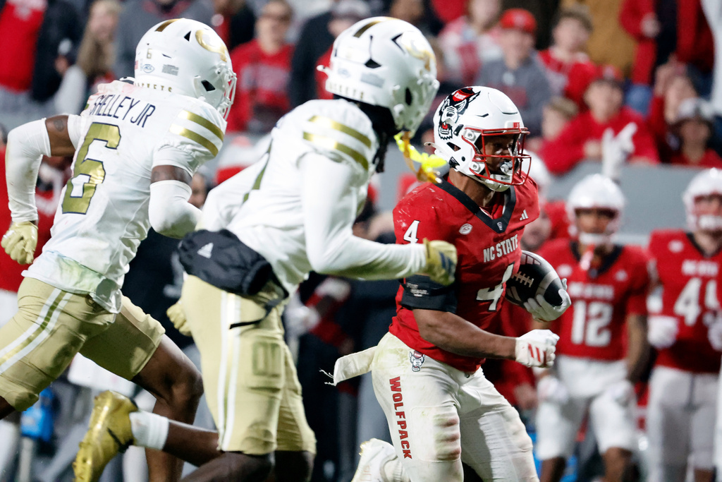 North Carolina State running back Jayden Scott (4) runs the ball away from Georgia Tech defenders during the second half of an NCAA college football game in Raleigh, N.C., Saturday, Nov. 1, 2025. (AP Photo/Karl DeBlaker)
