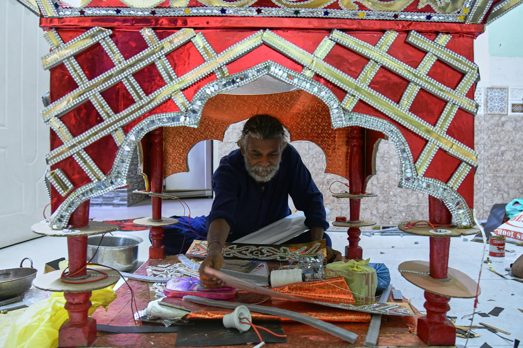 Raju Rathore, an artisan from Pakistani Hindu community, makes a replica of the mausoleum of Imam Hussain locally called 'Tazia', in preparation for the upcoming Ashoura, when Shiites Muslims mark the death of Hussein, at his home in Karachi, Pakistan, Tuesday, June 23, 2026. (AP Photo/Ali Raza)