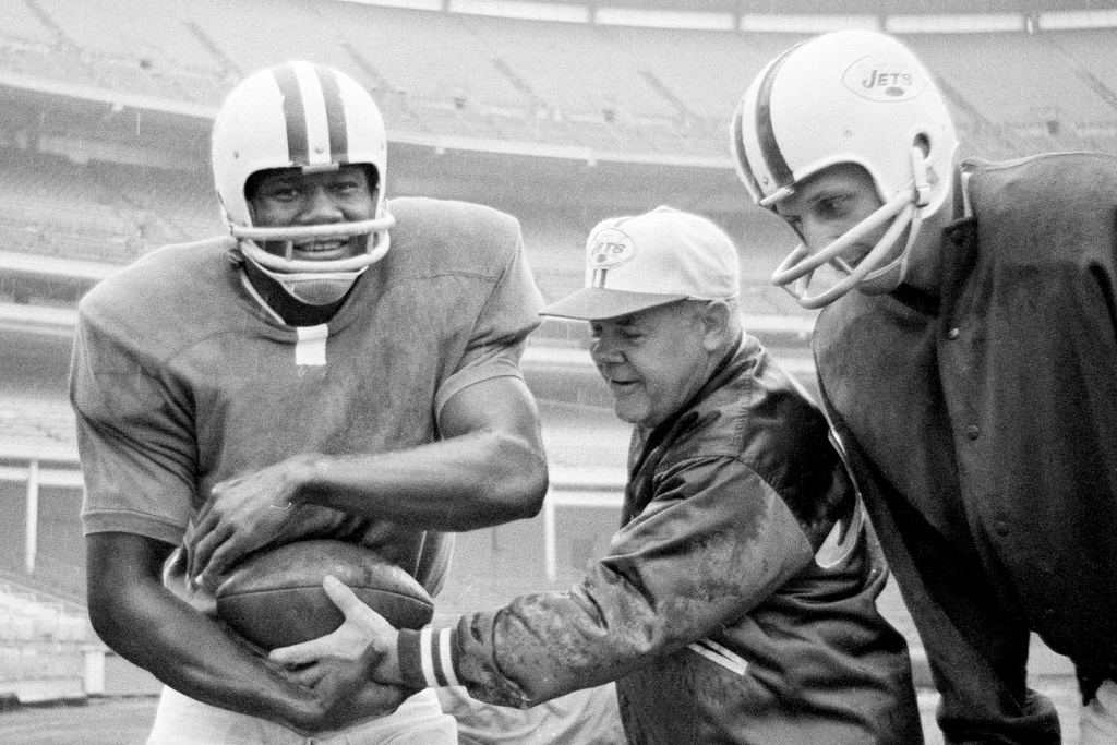 FILE - Weeb Ewbank, center, coach of the New York Jets, shows quarterback Dick Wood, right, the way to work the hand-off to Jets' leading running back Matt Snell during a workout on Nov. 5, 1964, in New York. (AP Photo/Harry Harris, File)