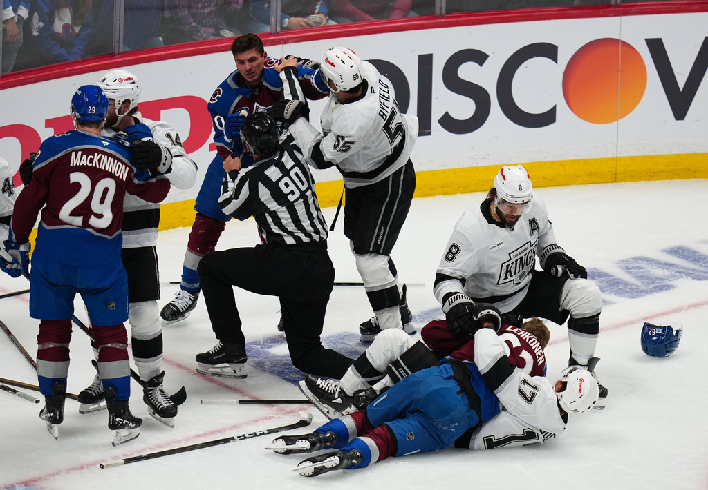 Linesman Travis Toomey (90) tries to break up a fight between Colorado Avalanche defenseman Sam Malinski (70) and Los Angeles Kings right wing Quinton Byfield (55) during the first period of Game 2 in the first round of the NHL hockey Stanley Cup playoffs, Tuesday, April 21, 2026, in Denver. (AP Photo/Jack Dempsey)