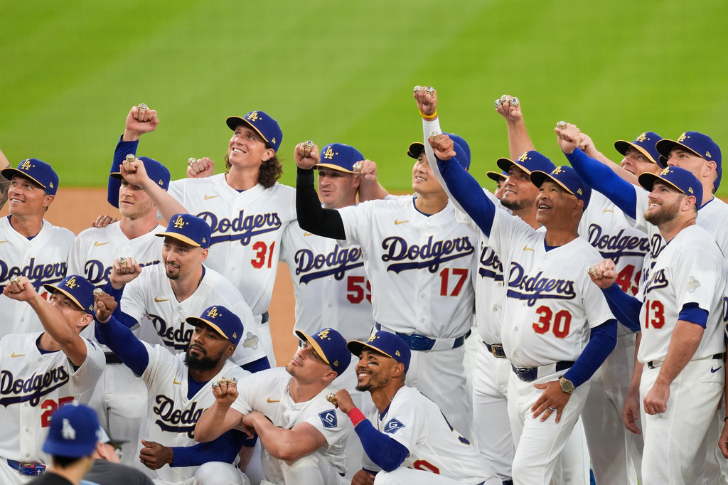 Los Angeles Dodgers players hold up hands to show off their World Series Champion rings during a ceremony prior to a baseball game against the Arizona Diamondbacks in Los Angeles, Friday, March 27, 2026. (AP Photo/Caroline Brehman)