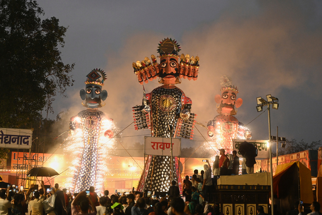 Effigies of demon king Ravana, centre, his son Meghnad and brother Kumbhkarna are set on fire, marking the end of Dussehra festival in New Delhi, India, Thursday, Oct. 2, 2025.(AP Photo/Deepanshu Aggarwal)