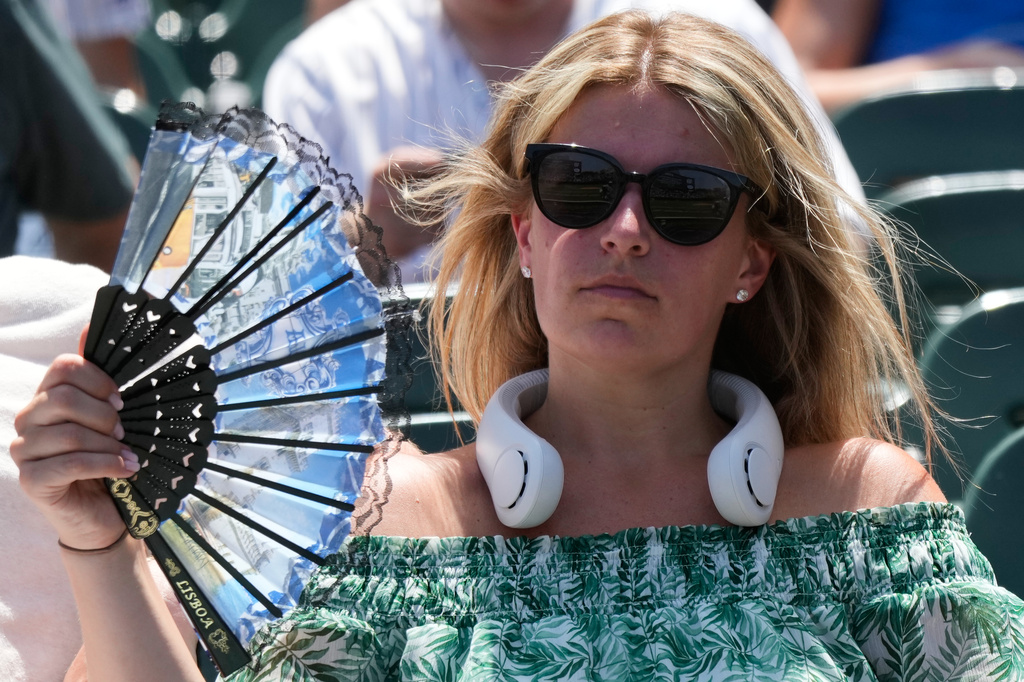 FILE - A baseball fan cools off before a game between the San Diego Padres and the Chicago Cubs in Chicago, July 1, 2026. (AP Photo/Nam Y. Huh, File)