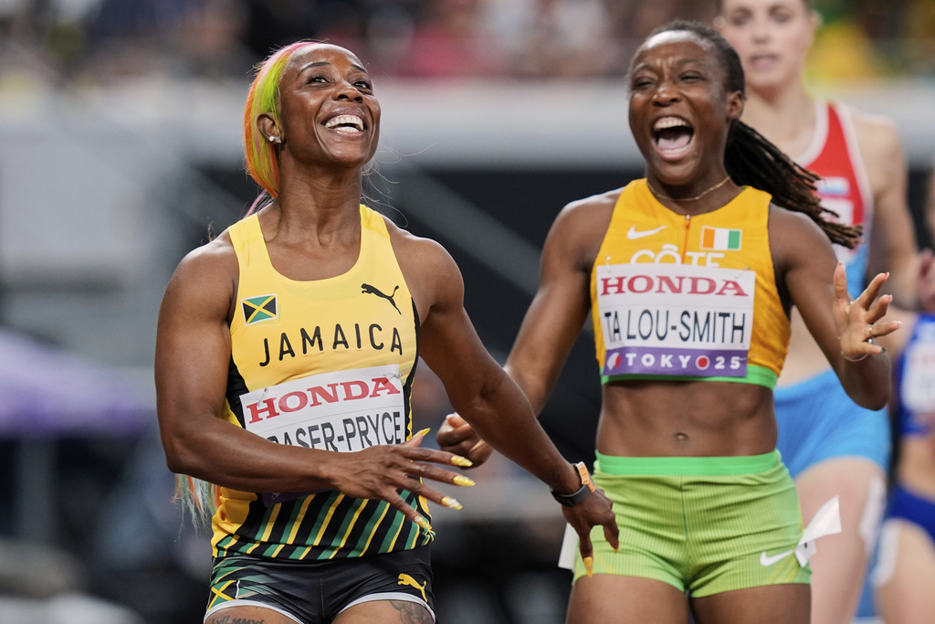 Jamaica's Shelly-Ann Fraser-Pryce, left, and The Ivory Coast's Marie-Josee Ta Lou-Smith react after crossing the finish line in the women's 100 meters heat at the World Athletics Championships in Tokyo, Saturday, Sept. 13, 2025. (AP Photo/Eugene Hoshiko)