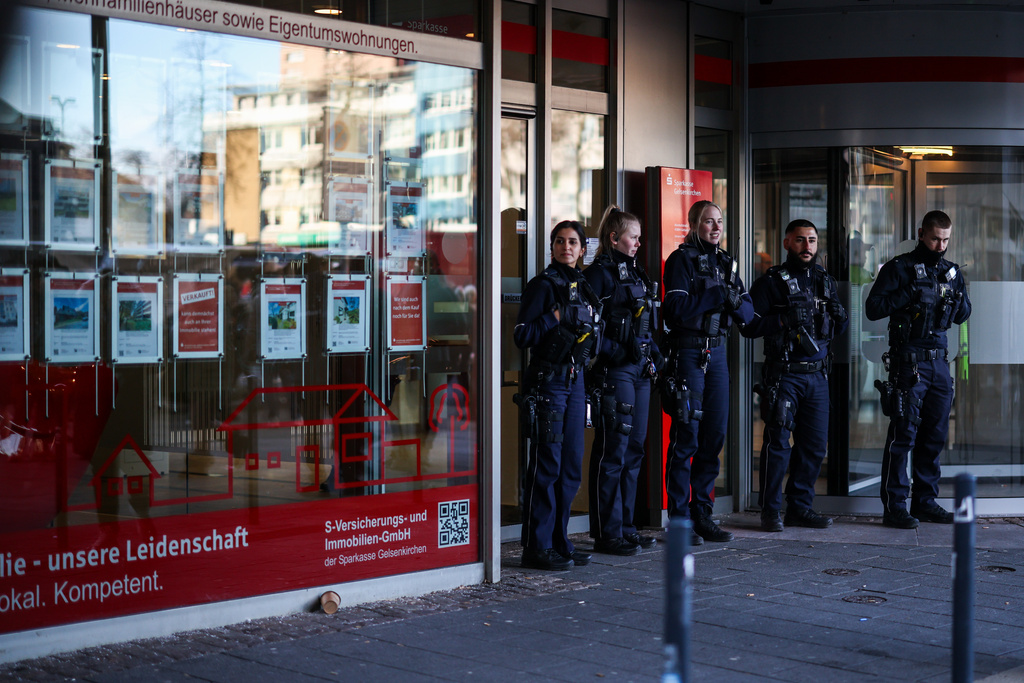 Police officers stand in front of the savings bank branch in the Buer district in Gelsenkirchen, Germany, Tuesday, Dec. 30, 2025 following a break-in into the bank's vault. (Christoph Reichwein/dpa via AP)