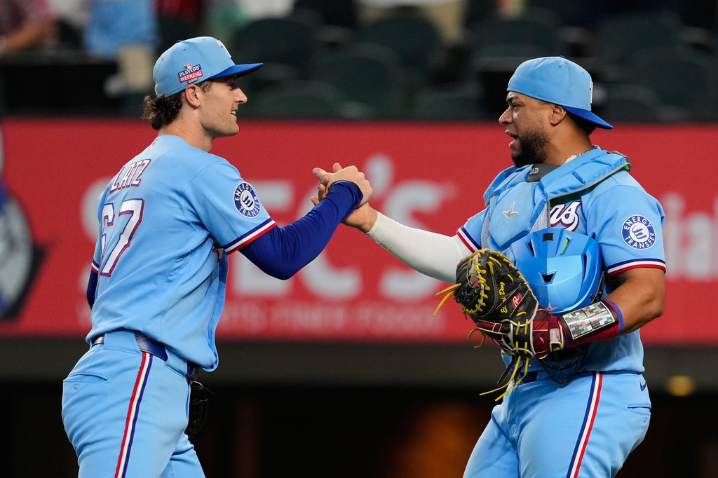 Texas Rangers' Jacob Latz, left, and Elias Díaz, right, celebrate the team's win in a baseball game against the Los Angeles Angels Sunday, Aug. 23, 2026, in Arlington, Texas. (AP Photo/Tony Gutierrez)