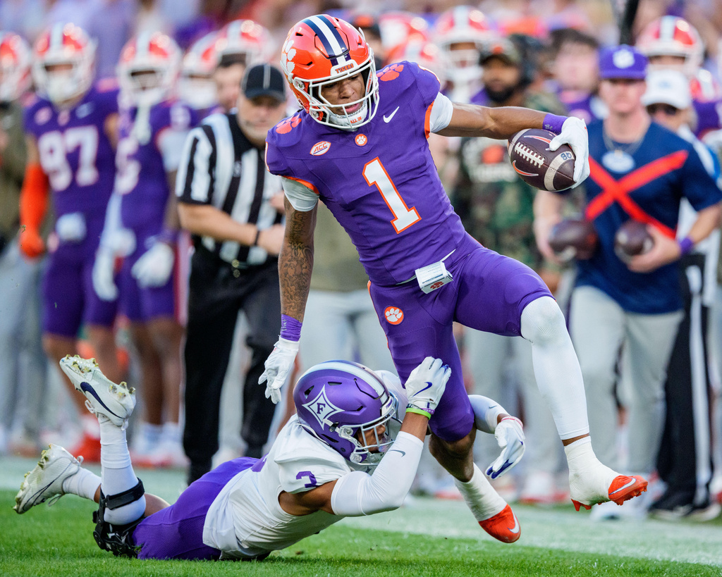 Furman safety Ak Burrell (3) tackles Clemson wide receiver T.J. Moore (1) in the first half of an NCAA college football game Saturday, Nov. 22, 2025, in Clemson, S.C. (AP Photo/Jacob Kupferman)