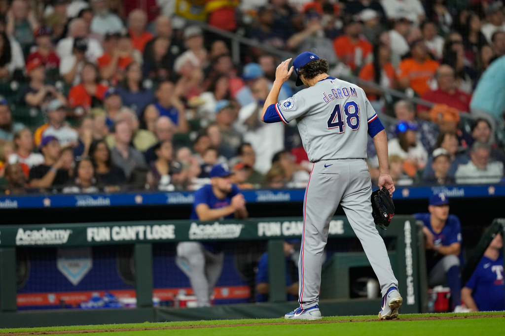 Texas Rangers starting pitcher Jacob Degrom walks toward the dugout after being pulled during the fourth inning of a baseball game against the Houston Astros Saturday, Aug. 1, 2026, in Houston. (AP Photo/David J. Phillip)