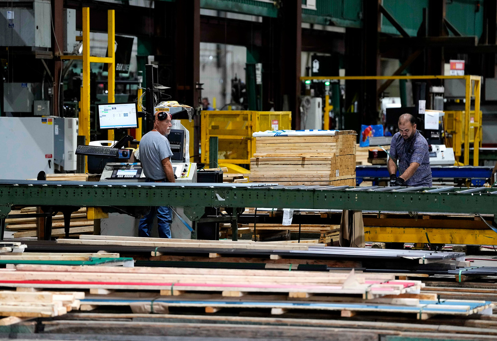 Workers are seen in the manufacturing plant of Ideal Roofing in Ottawa on Tuesday, Aug. 25, 2026. (Justin Tang/The Canadian Press via AP)