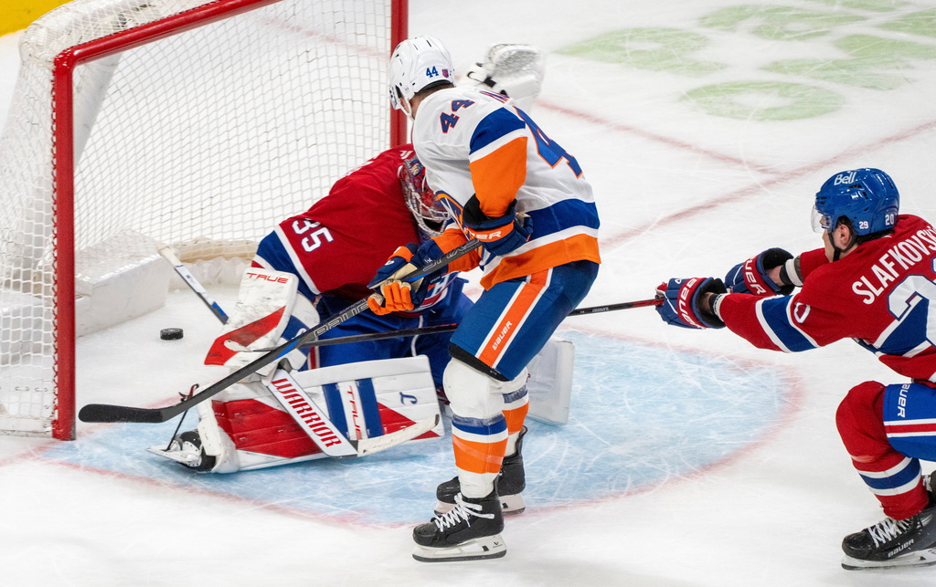 New York Islanders' Jean-Gabriel Pageau (44) scores on Montreal Canadiens goaltender Samuel Montembeault (35) during the overtime of an NHL hockey game in Montreal, Thursday, Feb. 26, 2026. (Christinne Muschi/The Canadian Press via AP)