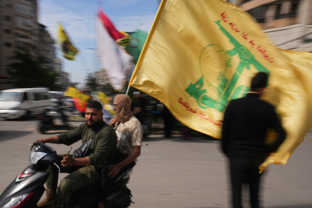 Men ride a scooter while waving a Hezbollah flag during a small gathering in Dahiyeh, Beirut's southern suburbs, Lebanon, Saturday, April 25, 2026. (AP Photo/Hassan Ammar)
