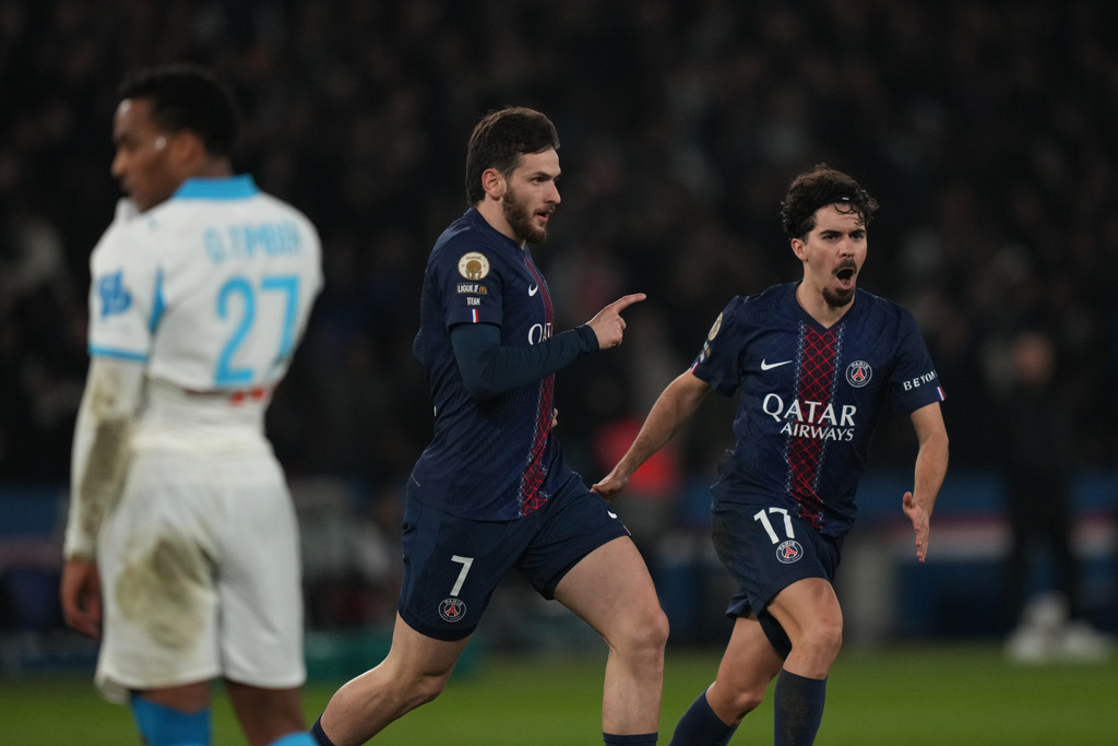 PSG's Khvicha Kvaratskhelia, center, celebrates after scoring his side's fourth goal during the French League One soccer match between Paris Saint-Germain and Marseille in Paris, Sunday, Feb. 8, 2026. (AP Photo/Thibault Camus)
