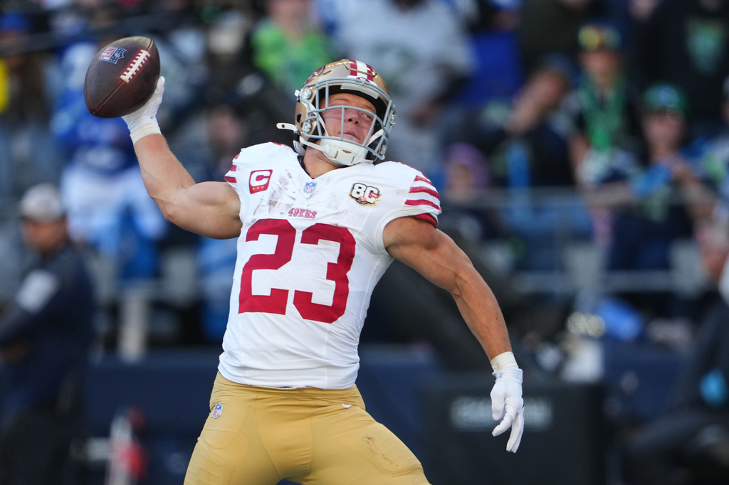 San Francisco 49ers running back Christian McCaffrey (23) spikes the ball after scoring on a touchdown run against the Seattle Seahawks during the first half of an NFL football game Sunday, Oct. 11, 2026, in Seattle. (AP Photo/Lindsey Wasson)