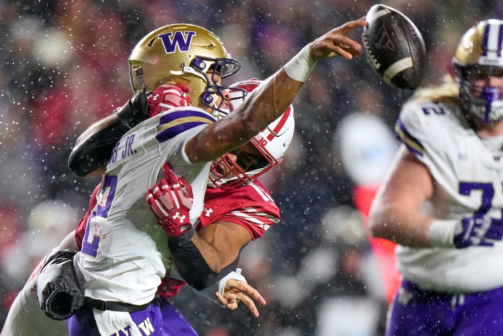 Washington's Demond Williams Jr. is called for intentional grounding as he is hit by Wisconsin's Sebastian Cheeks during the second half of an NCAA college football game Saturday, Nov. 8, 2025, in Madison, Wis. (AP Photo/Morry Gash)