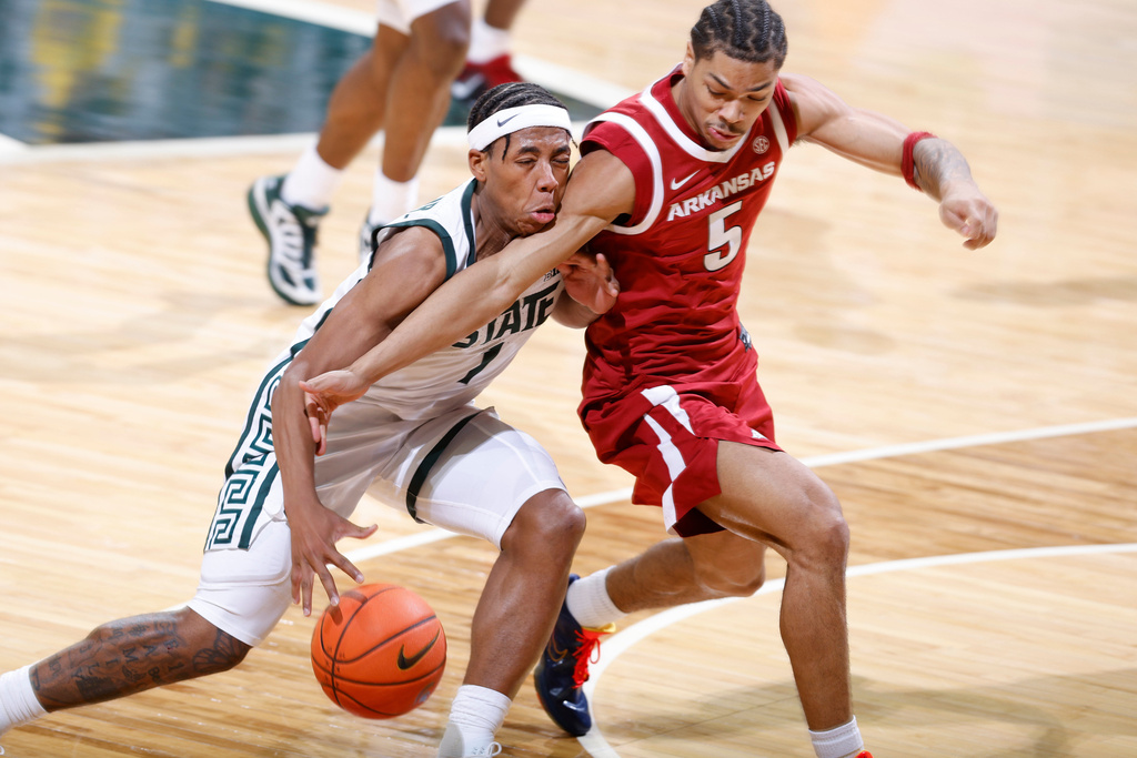 Arkansas guard Darius Acuff Jr. (5) reaches in and fouls Michigan State guard Jeremy Fears Jr. (1) during the first half of an NCAA college basketball game, Saturday, Nov. 8, 2025, in East Lansing, Mich. (AP Photo/Al Goldis)