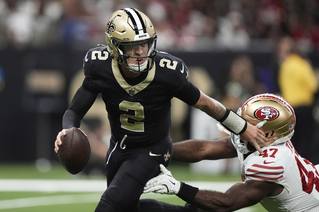 New Orleans Saints quarterback Spencer Rattler (2) rolls out as San Francisco 49ers defensive end Bryce Huff (47) applies pressure during the first half of an NFL football game in New Orleans, Sunday, Sept. 14, 2025. (AP Photo/Gerald Herbert)