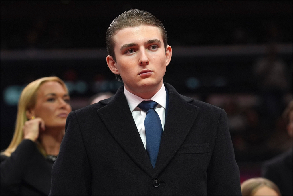 FILE - Barron Trump watches as his father, President Donald Trump attends an indoor Presidential Inauguration parade event at Capital One Arena, in Washington, Jan. 20, 2025. (AP Photo/Evan Vucci, File)