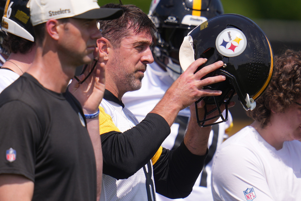 Pittsburgh Steelers quarterback Aaron Rodgers, center, puts on his helmet whole participating in the football team's OTA workout in Pittsburgh, Monday, May 18, 2026. (AP Photo/Gene J. Puskar)