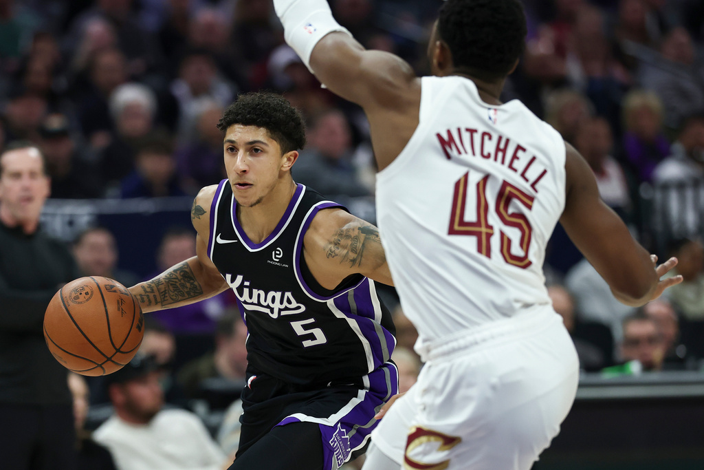 Sacramento Kings guard Nique Clifford (5) drives to the basket with Cleveland Cavaliers guard Donovan Mitchell (45) defending during the first half of an NBA basketball game Saturday, Feb. 7, 2026, in Sacramento, Calif. (AP Photo/Sara Nevis)