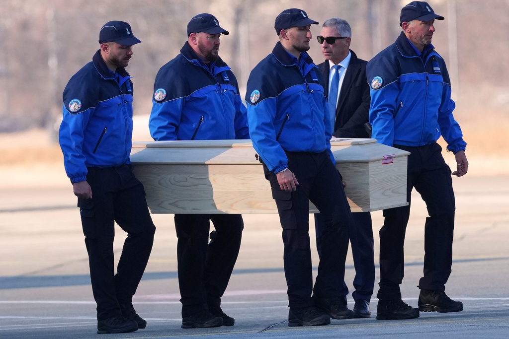 Police officers carry a coffin with the body of one of six Italians at the Military Airport in Sion, Swiss Alps, Switzerland, Monday, Jan. 5, 2026, following a devastating fire in a bar in Crans-Montana during the New Year's celebrations. (AP Photo/Antonio Calanni)