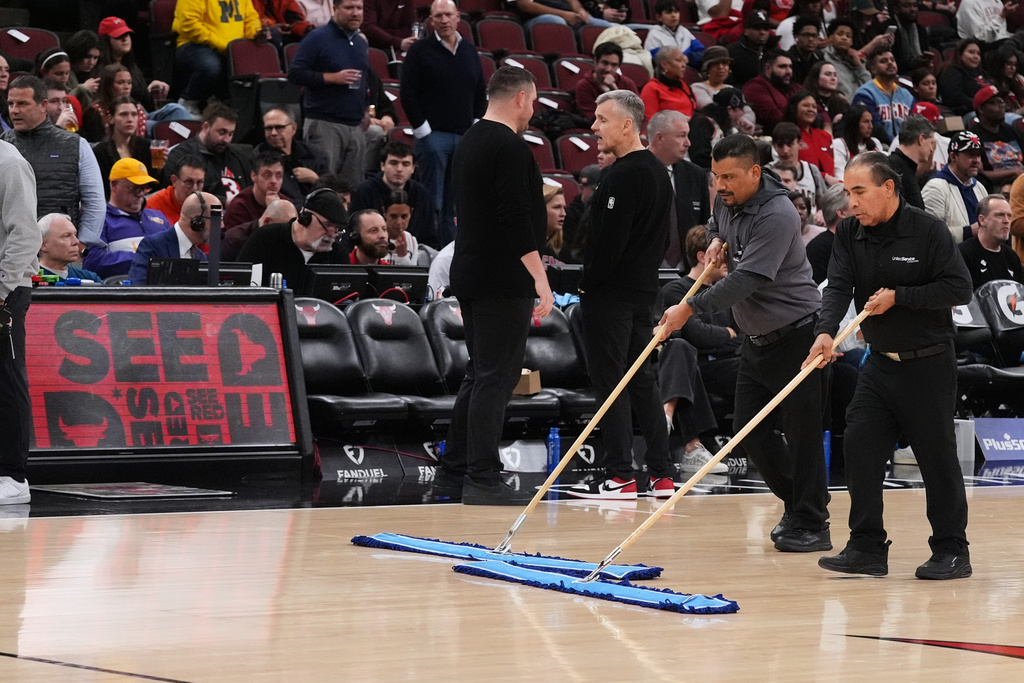 United center employees clean the court during a delay before an NBA basketball game between the Chicago Bulls and the Miami Heat in Chicago, Thursday, Jan. 8, 2026. (AP Photo/Nam Y. Huh)