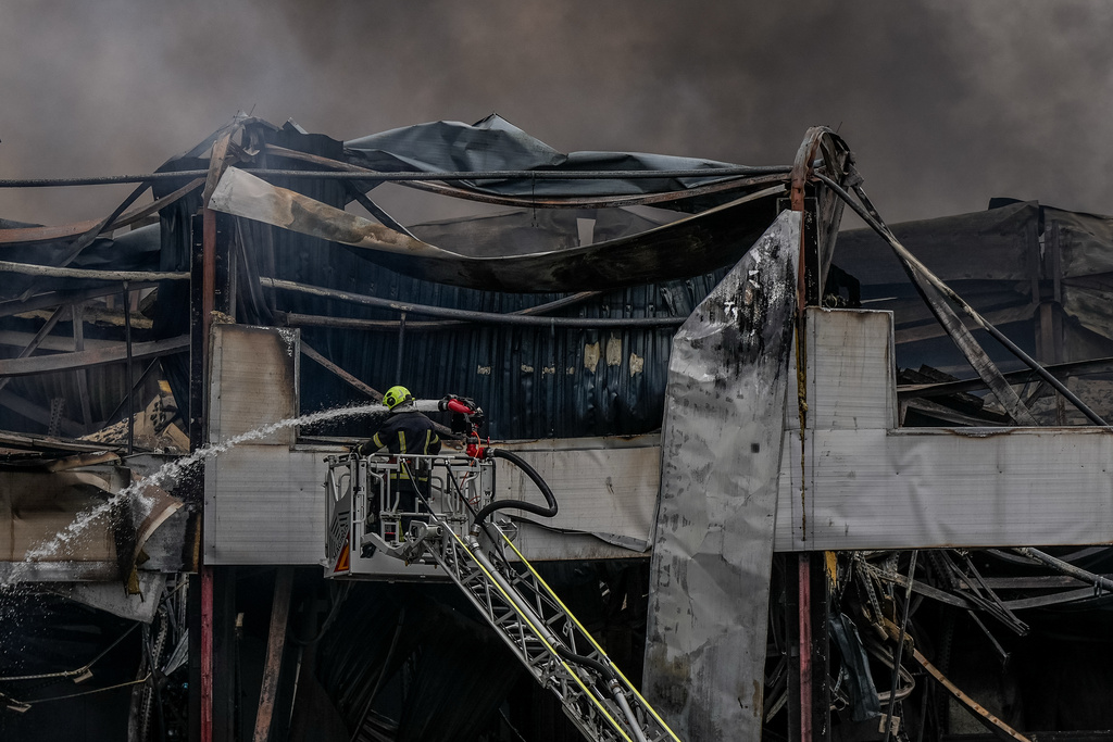 A firefighter works to extinguish a fire at a warehouse following a Russian attack, Saturday, Oct. 25, 2025, in Kyiv, Ukraine. (AP Photo/Julia Demaree Nikhinson)
