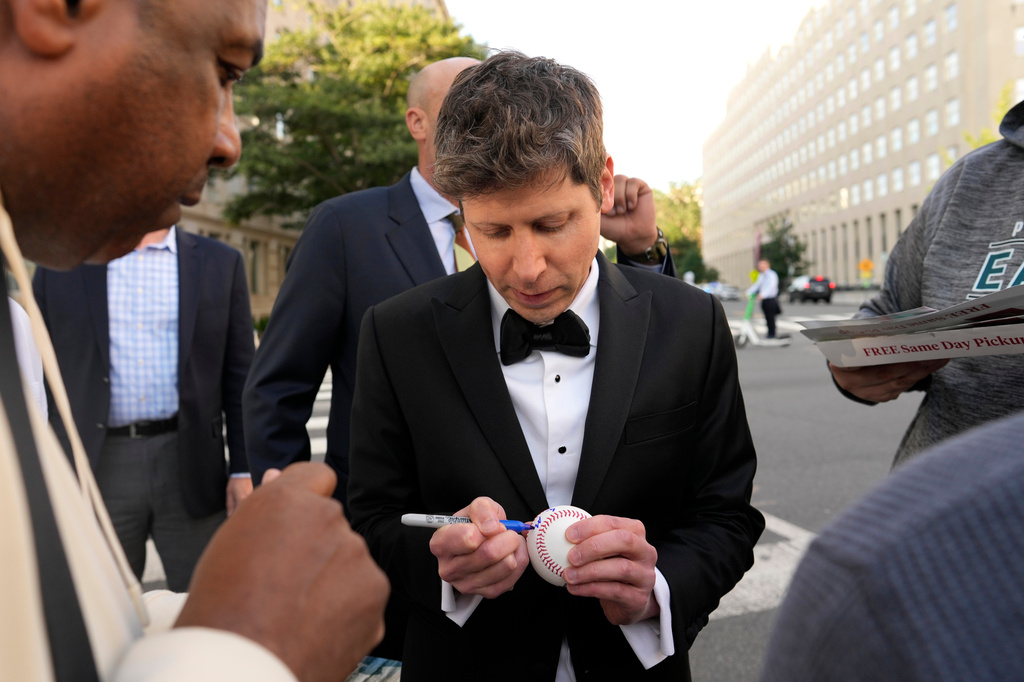 OpenAI CEO Sam Altman signs items as he walks to the White House to attend a state dinner hosted for China's President Xi Jinping, Thursday, Sept. 24, 2026, in Washington. (AP Photo/Carolyn Kaster)