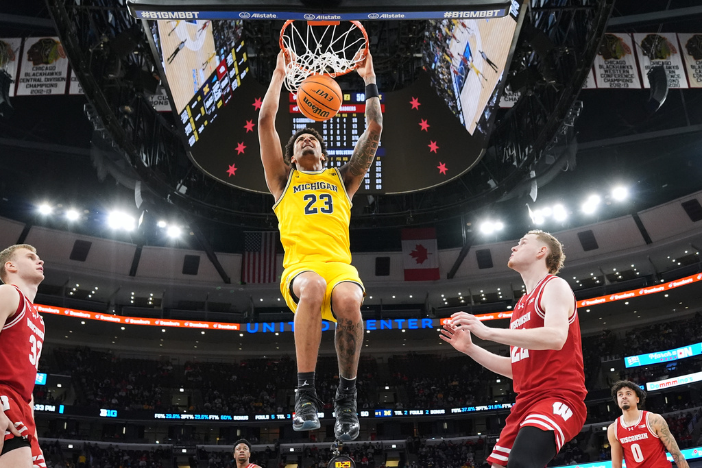 Michigan forward Yaxel Lendeborg hangs from the rim after dunking during the second half of an NCAA college basketball game against Wisconsin in the semifinals of the Big 10 Conference tournament, Saturday, March 14, 2026, in Chicago. (AP Photo/Nam Y. Huh)
