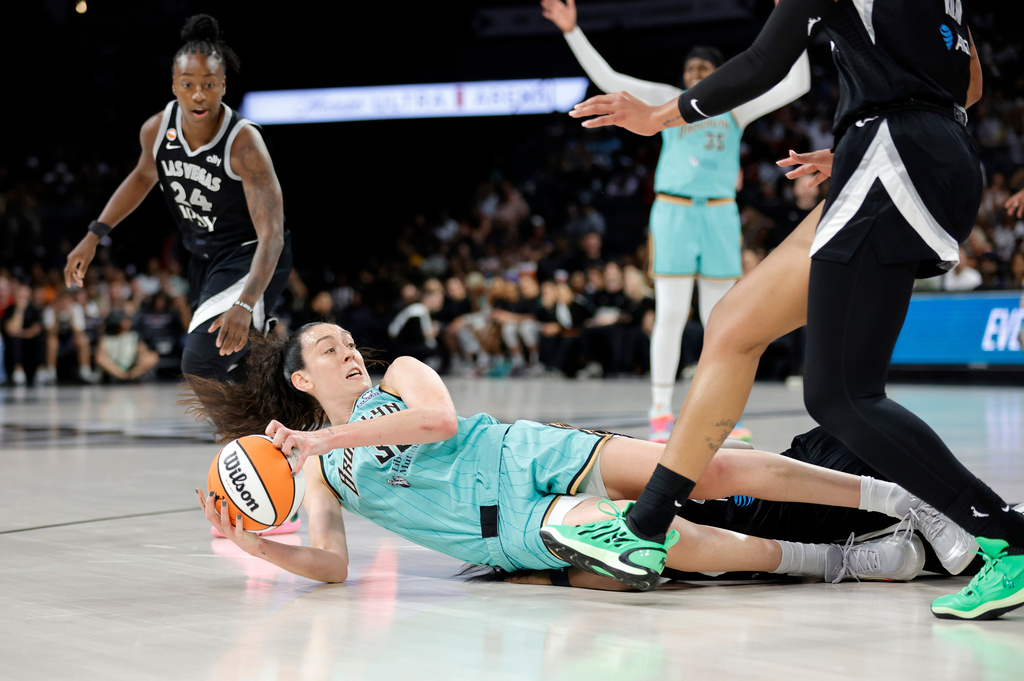 New York Liberty forward Breanna Stewart (30) recovers a loose ball as Las Vegas Aces guard Jewell Loyd (24) looks on during the first half of an WNBA basketball game Tuesday, June 23, 2026, in Las Vegas. (Steve Marcus/Las Vegas Sun via AP)
