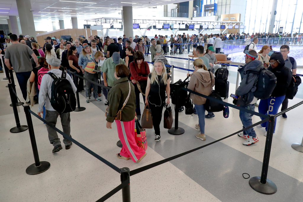 Air travelers endure long lines and two-hour wait times at the TSA security check point at Terminal E at the George Bush Intercontinental Airport Friday, March 20, 2026, in Houston. (AP Photo/Michael Wyke)