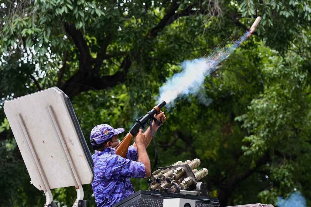 A policeman fires tear gas to disperse supporters of the Cockroach Janta Party as they attempt to march toward India's Parliament, demanding the resignation of the education minister, in New Delhi, India, Monday, July 20, 2026. (AP Photo/Manish Swarup)