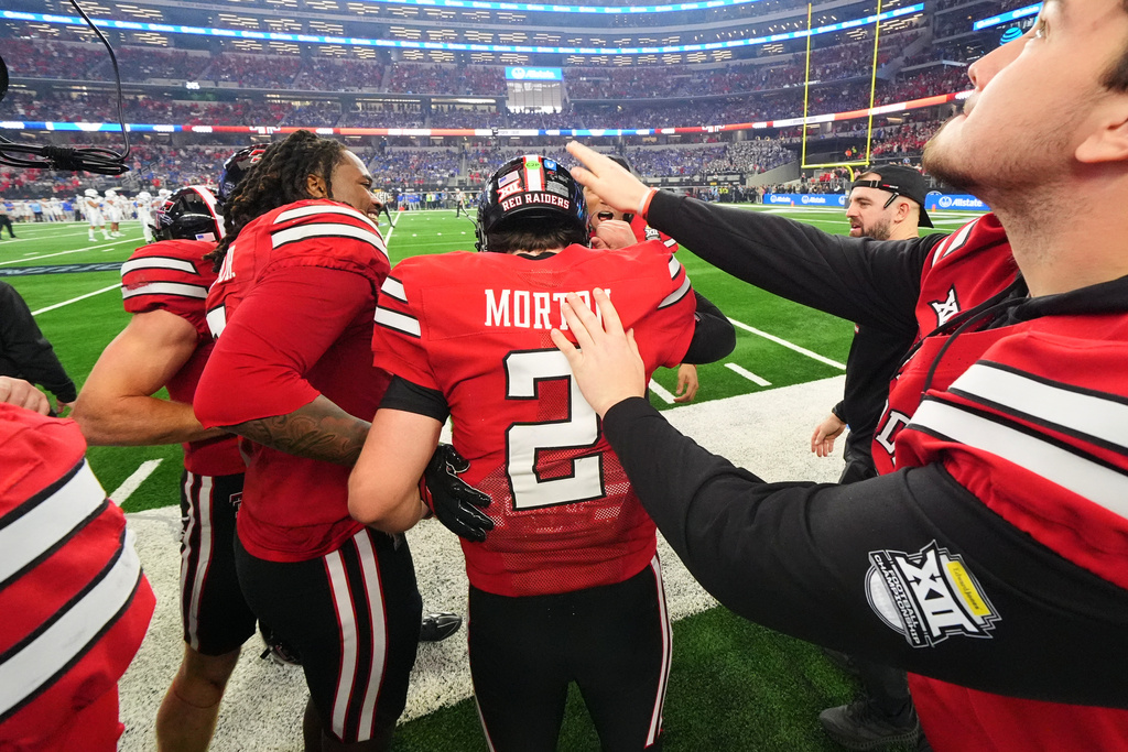 Texas Tech quarterback Behren Morton (2) celebrates with teammates on the sideline late in the second half of a Big 12 Conference championship NCAA college football game against BYU Saturday, Dec. 6, 2025, in Arlington, Texas. (AP Photo/Julio Cortez)