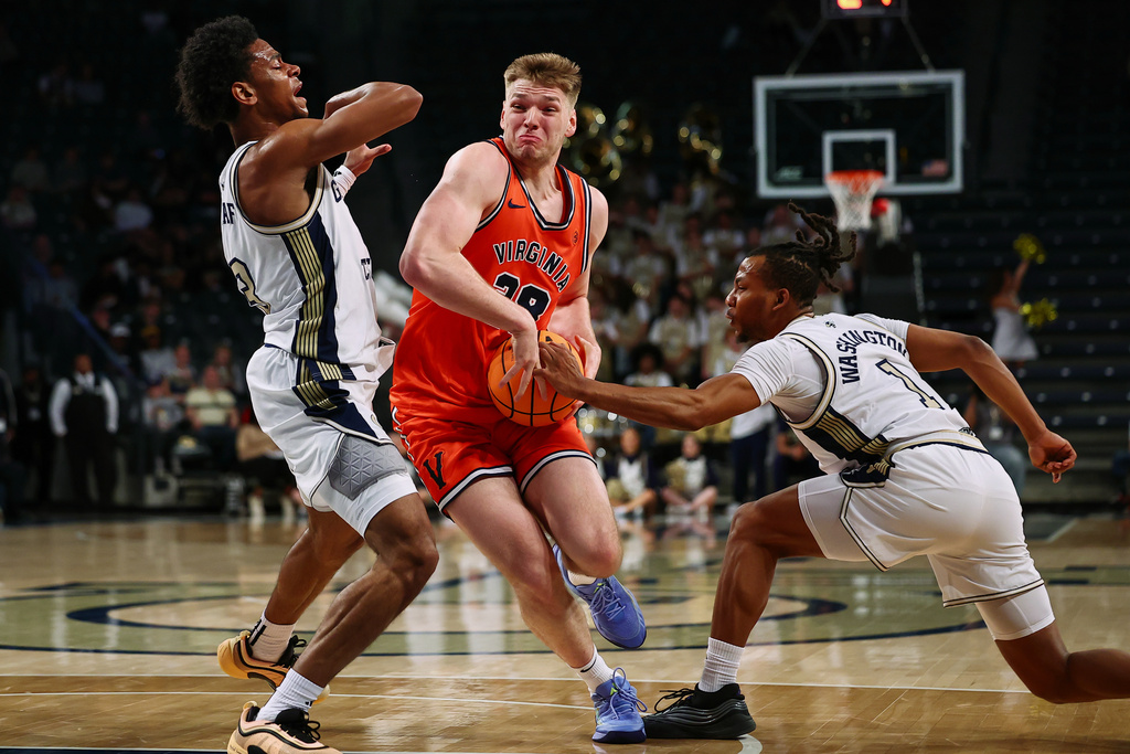 Virginia forward Thijs de Ridder (28) dribbles against Georgia Tech guards Jaeden Mustaf, left, and Lamar Washington, right, during the first half of an NCAA college basketball game, Wednesday, Feb. 18, 2026, in Atlanta. (AP Photo/Colin Hubbard)