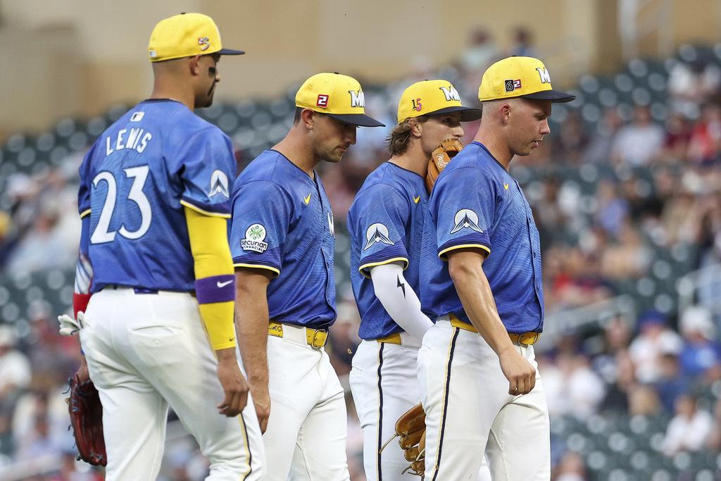 Minnesota Twins starting pitcher Pierson Ohl, far right, reacts during a mound visit in the first inning of a baseball game against the Detroit Tigers, Friday, Aug. 15, 2025, in Minneapolis. (AP Photo/Matt Krohn)
