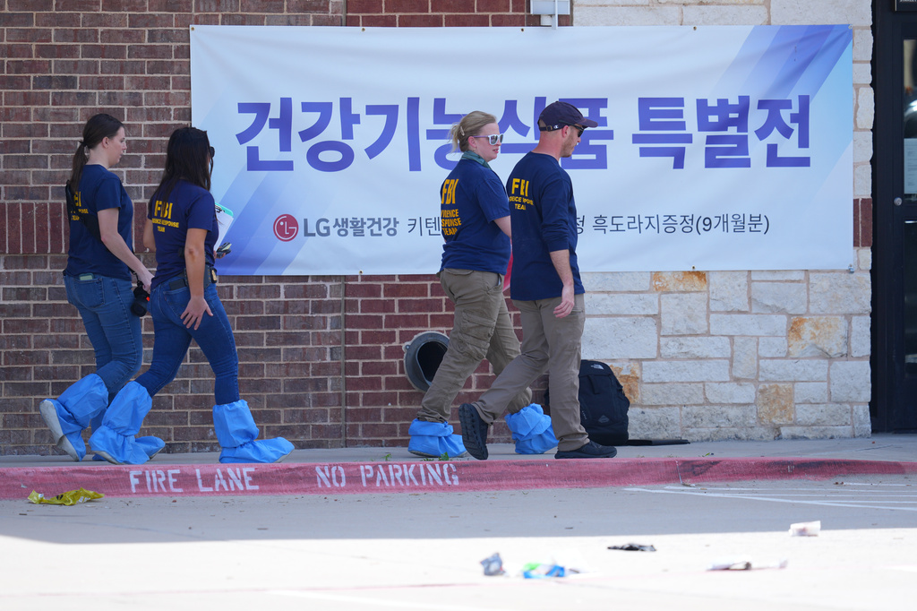 Officials respond to the scene of a shooting Tuesday, May 5, 2026, at K Towne Plaza in Carrollton, Texas. (AP Photo/Julio Cortez)