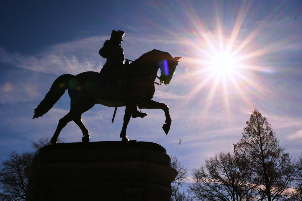 The sun shines over a statue of George Washington on horseback at the Public Garden, Friday, Feb. 13, 2026, in Boston. (AP Photo/Charles Krupa)