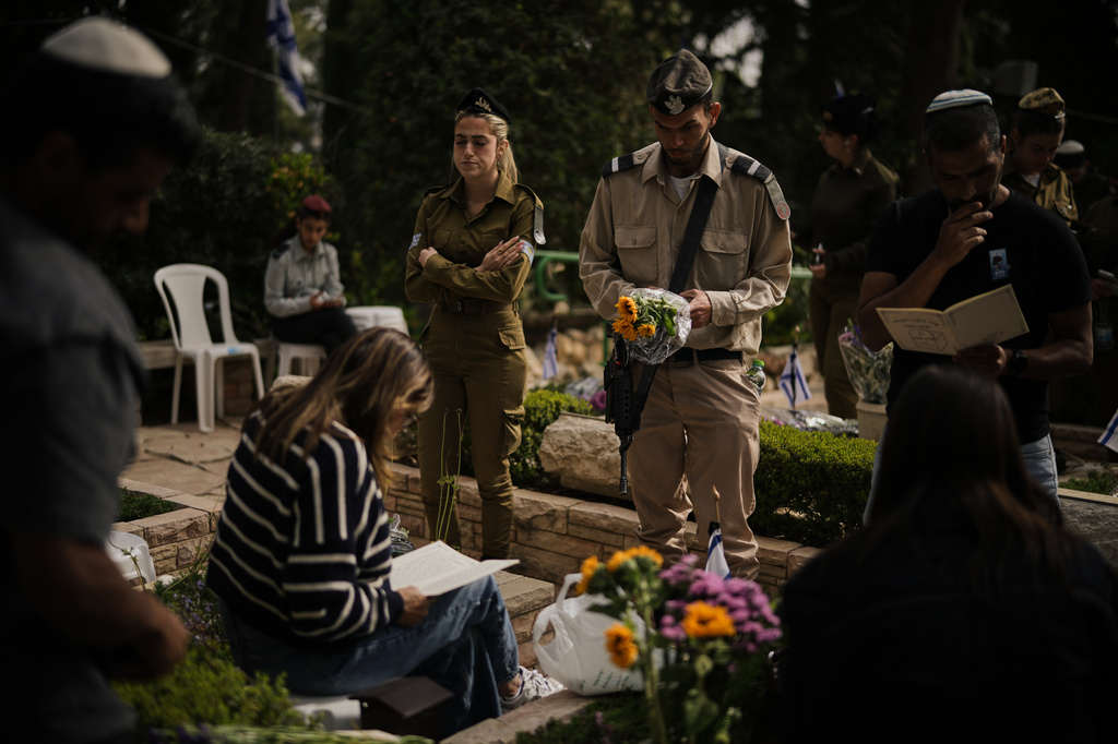 People visit the graves of their relatives as they mark Israel's annual Memorial Day, honoring soldiers killed in the nation's conflicts and victims of nationalistic attacks, at Mount Herzl military cemetery in Jerusalem, Tuesday, April 21, 2026. (AP Photo/Leo Correa)