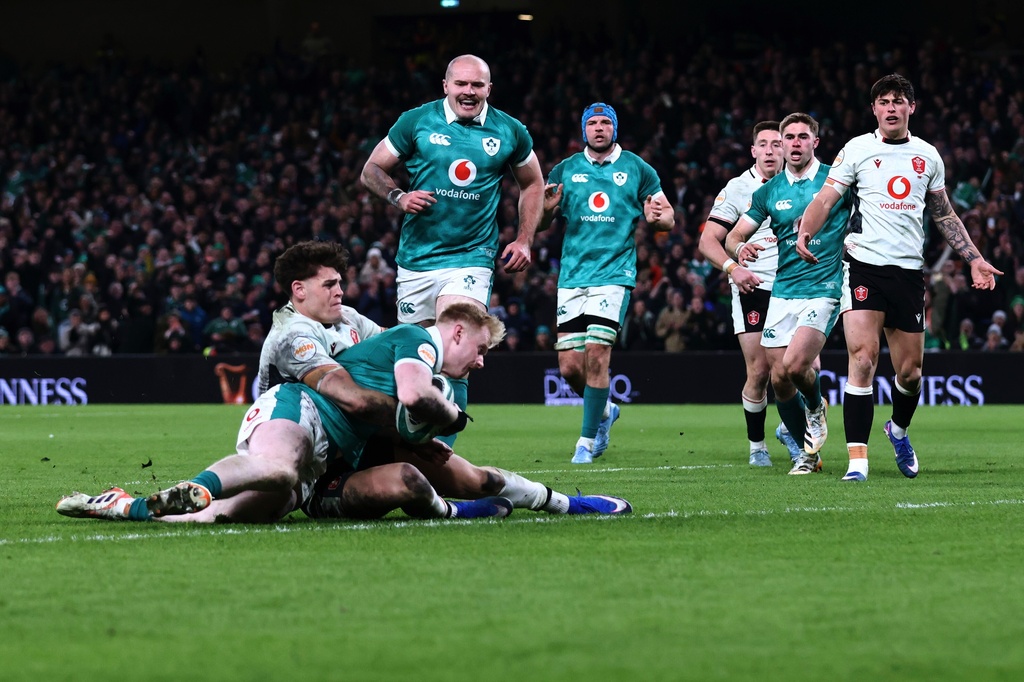 Ireland's Garry Ringrose, front, scores a try as Wales' Eddie James tackles him during a Six Nations rugby union match between Ireland and Wales in Dublin, Ireland, Friday, March 6, 2026. (AP Photo/Peter Morrison)
