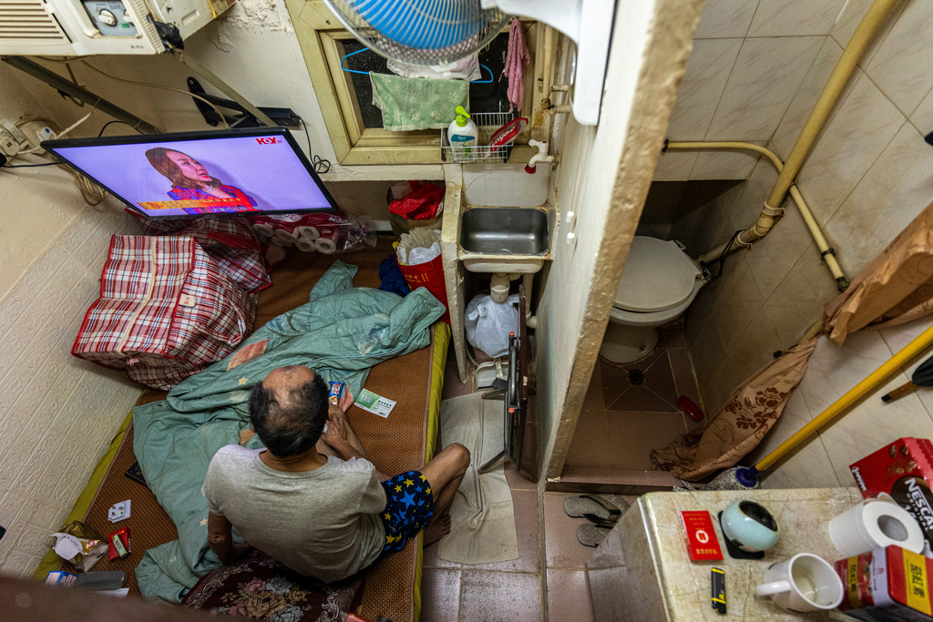 FILE - A resident who gave his name as Cheung watches television at his subdivided flat in Sham Shui Po district of Hong Kong, Feb. 6, 2025. (AP Photo/Chan Long Hei, File)