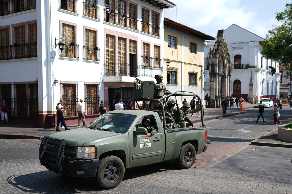 Soldiers patrol Uruapan, Mexico, Friday, Nov. 21, 2025, as Michoacan state prosecutor officers detain a suspect in the killing of the city's Mayor Carlos Manzo Rodriguez. (AP Photo/Eduardo Verdugo)