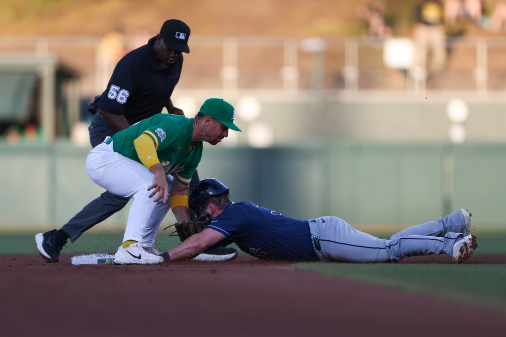 Athletics second baseman Donovan Walton, middle, tags out Tampa Bay Rays' Liam Hicks, right, as Hicks attempts to tag up from first base on a sacrifice fly from Tampa Bay Rays' Chandler Simpson, not shown, during the third inning of a baseball game Tuesday, Aug. 11, 2026, in West Sacramento, Calif. (AP Photo/Scott Marshall)