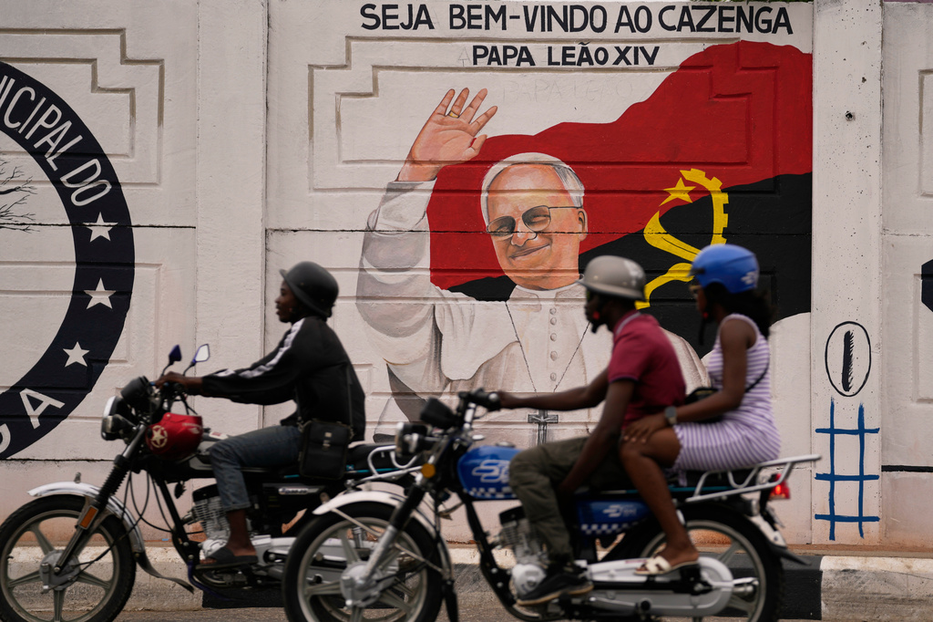 People traveling on a motorcycles ride past a mural featuring Pope Leo XIV, in Luanda, South Africa, Thursday, April 16, 2026. (AP Photo/Themba Hadebe)
