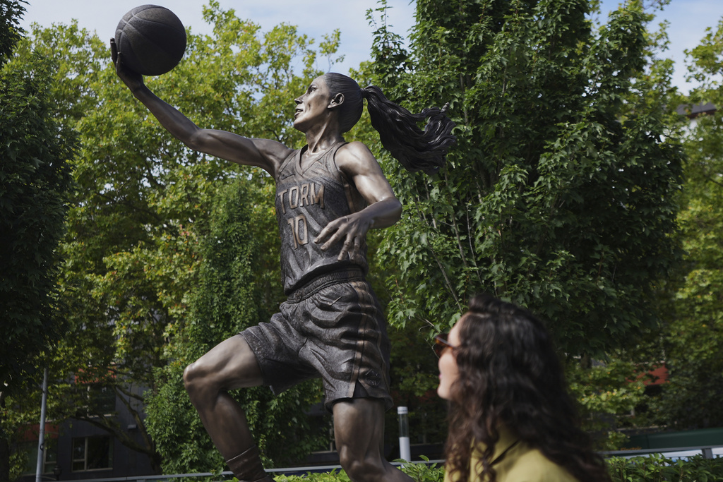 Former Seattle Storm WNBA basketball point guard Sue Bird looks up at her statue after it was unveiled outside Climate Pledge Arena, Sunday, Aug. 17, 2025, in Seattle. (AP Photo/Lindsey Wasson)