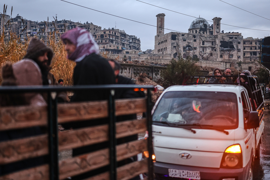 Residents flee the Sheikh Maqsoud neighborhood of Aleppo, Syria, Friday, Jan. 9, 2026, after the government declared the area a closed military zone following days of clashes between government forces and Kurdish fighters. (AP Photo/Ghaith Alsayed)