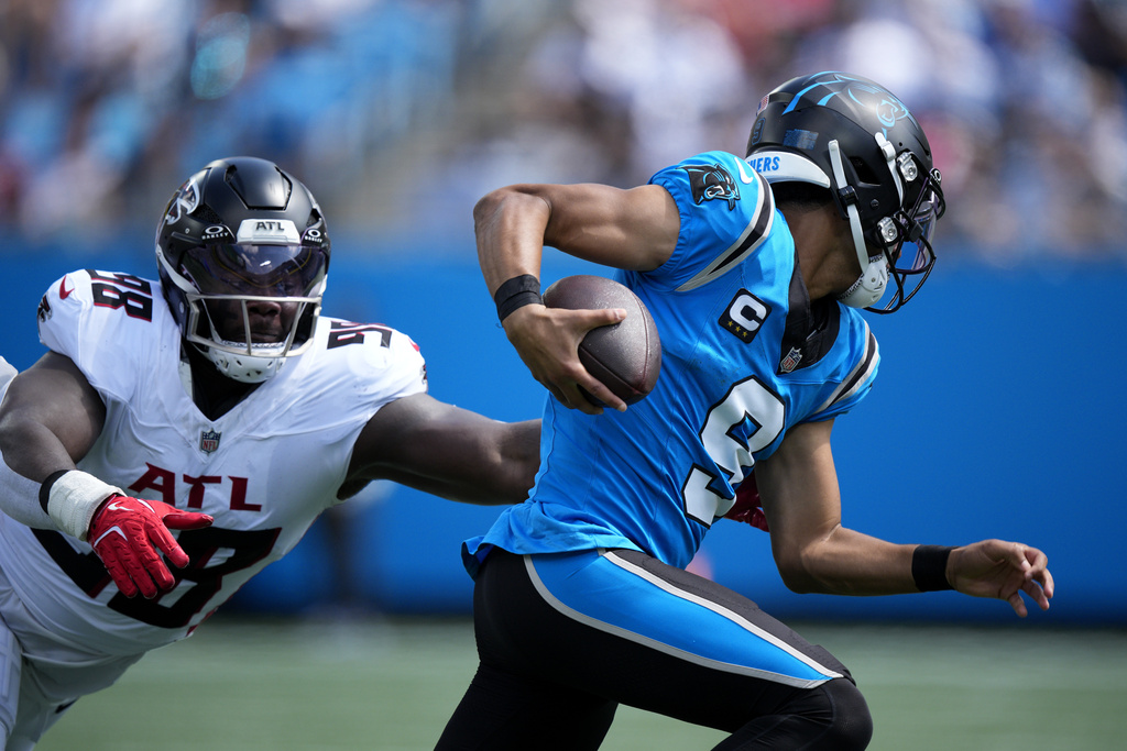 Carolina Panthers quarterback Bryce Young runs past Atlanta Falcons defensive tackle Ruke Orhorhoro during the first half of an NFL football game, Sunday, Sept. 21, 2025, in Charlotte, N.C. (AP Photo/Jacob Kupferman)