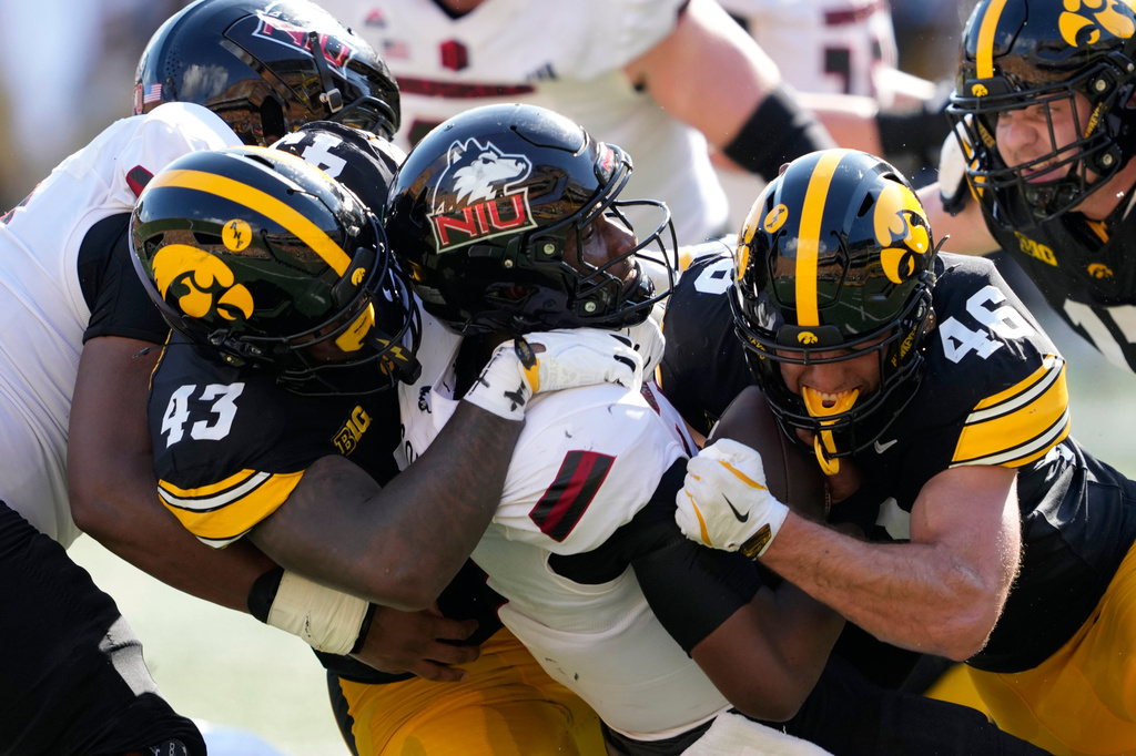Northern Illinois quarterback Jalen Macon, center, is sacked by Iowa defensive lineman Kahmari Brown (43) and linebacker Preston Ries (46) during the first half of an NCAA college football game, Saturday, Sept. 5, 2026, in Iowa City, Iowa. (AP Photo/Charlie Neibergall)