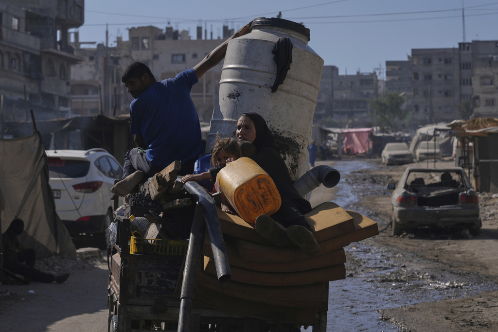 Displaced Palestinians fleeing northern Gaza Strip move with their belongings on a street in Gaza City, Thursday, Aug. 28, 2025. (AP Photo/Abdel Kareem Hana)