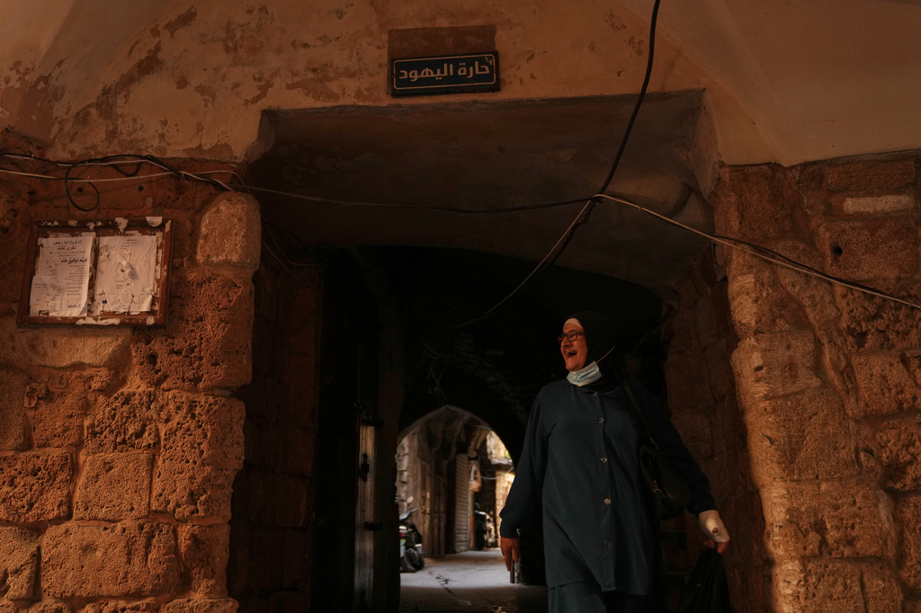 A woman walks beneath a sign that reads in Arabic "Jewish Quarter," in the old city of Sidon, southern Lebanon, Friday, Sept. 25, 2026. (AP Photo/Hassan Ammar)