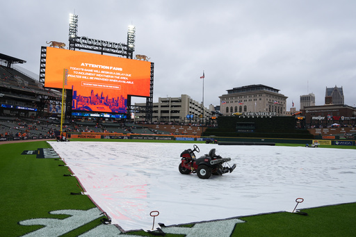 A tarp covers the field as rain falls while a message is seen on a video board alerting fans the start of Game 3 of baseball's American League Division Series between the Detroit Tigers and the Seattle Mariners will be delayed Tuesday, Oct. 7, 2025, in Detroit. (AP Photo/Ryan Sun) A tarp covers the field as rain falls while a message is seen on a video board alerting fans the start of Game 3 of baseball's American League Division Series between the Detroit Tigers and the Seattle Mariners will be delayed Tuesday, Oct. 7, 2025, in Detroit. (AP Photo/Ryan Sun)
